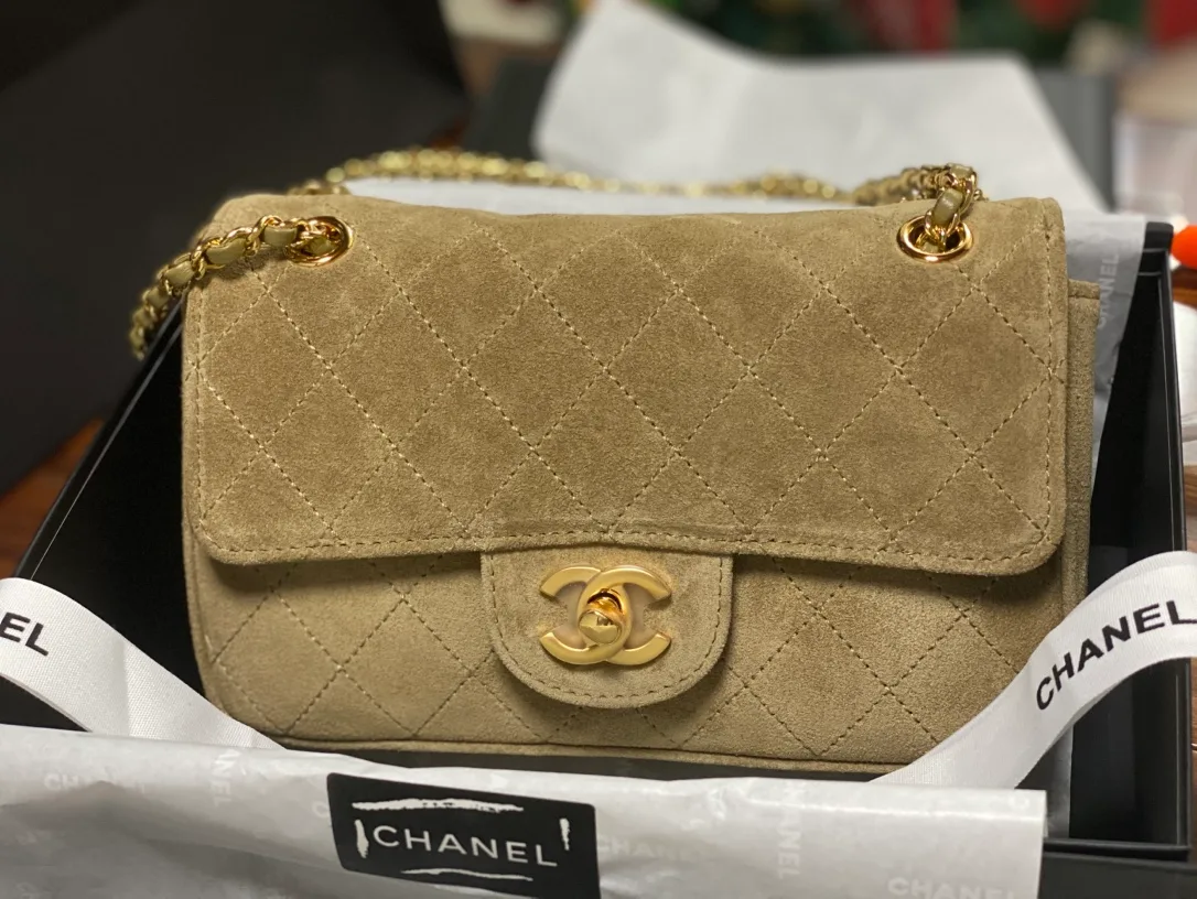 Chanel Classic Flap Medium: Flap-Bag aus beigem, gestepptem Wildleder mit Doppel-C-Drehverschluss und goldener Kette.