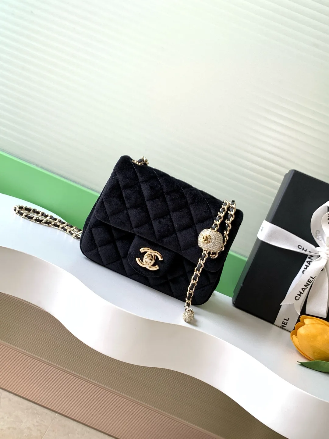 Chanel Classic Flap: sac à rabat en velours noir matelassé, avec fermoir à double C et chaîne dorée.